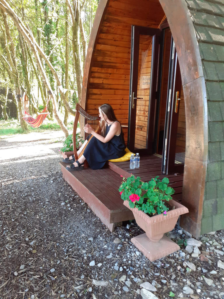 camping pod, with harpist playing in the woods
